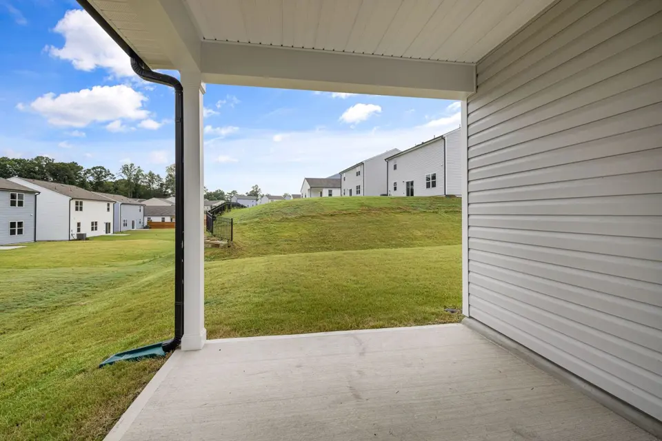 Plain concrete patio beside a covered residential porch
